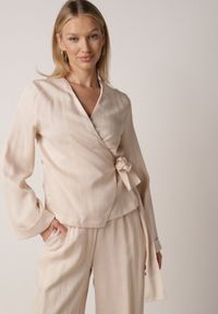 Born2be - Beżowa Kopertowa Bluzka z Wiskozy Ozdobiona Wiązaniem Velanitte. Okazja: na co dzień. Kolor: beżowy. Materiał: wiskoza. Wzór: aplikacja. Styl: casual, elegancki, wizytowy #6