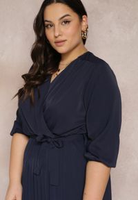 Renee - Granatowa Kopertowa Sukienka z Gumką i Paskiem w Talii Zdobiona Plisowaniem Kaylina. Kolekcja: plus size. Kolor: niebieski. Wzór: aplikacja. Typ sukienki: kopertowe