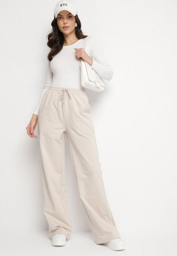 Born2be - Beżowe Bawełniane Spodnie Dresowe o Szerokim Kroju z Lampasami Alarita. Okazja: na co dzień. Stan: podwyższony. Kolor: beżowy. Materiał: bawełna, dresówka. Styl: casual, elegancki, sportowy, klasyczny