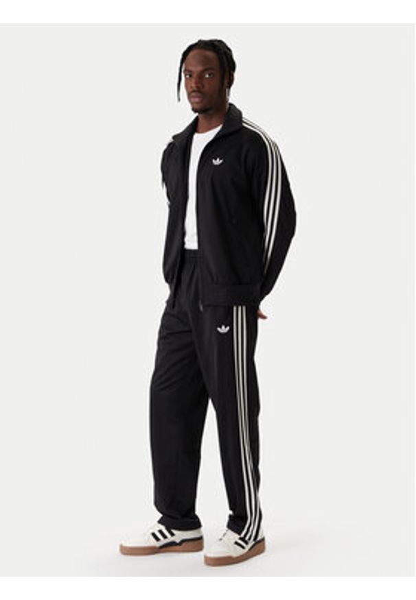 Adidas - adidas Spodnie dresowe Firebird KD8315 Czarny Loose Fit. Kolor: czarny. Materiał: syntetyk