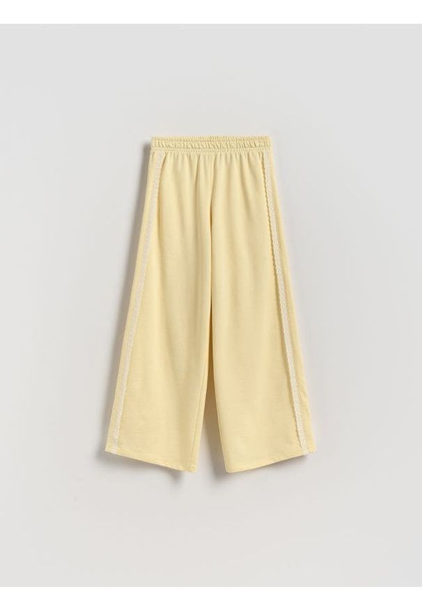 Reserved - Spodnie dresowe z ażurowymi wstawkami - jasnożółty. Kolor: żółty. Materiał: dresówka. Wzór: ażurowy