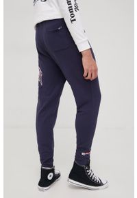Tommy Jeans spodnie dresowe bawełniane DM0DM12949.PPYY męskie kolor granatowy z nadrukiem. Kolor: niebieski. Materiał: bawełna, dresówka. Wzór: nadruk #2
