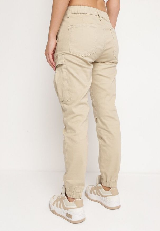 Born2be - Beżowe Bawełniane Joggery Jeansy z Gumką w Pasie i Kieszeniami z Klapami Nericella. Okazja: na co dzień. Kolor: beżowy. Styl: elegancki, casual