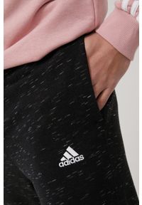 Adidas - adidas spodnie męskie kolor czarny melanżowe. Kolor: czarny. Materiał: materiał, dzianina. Wzór: melanż
