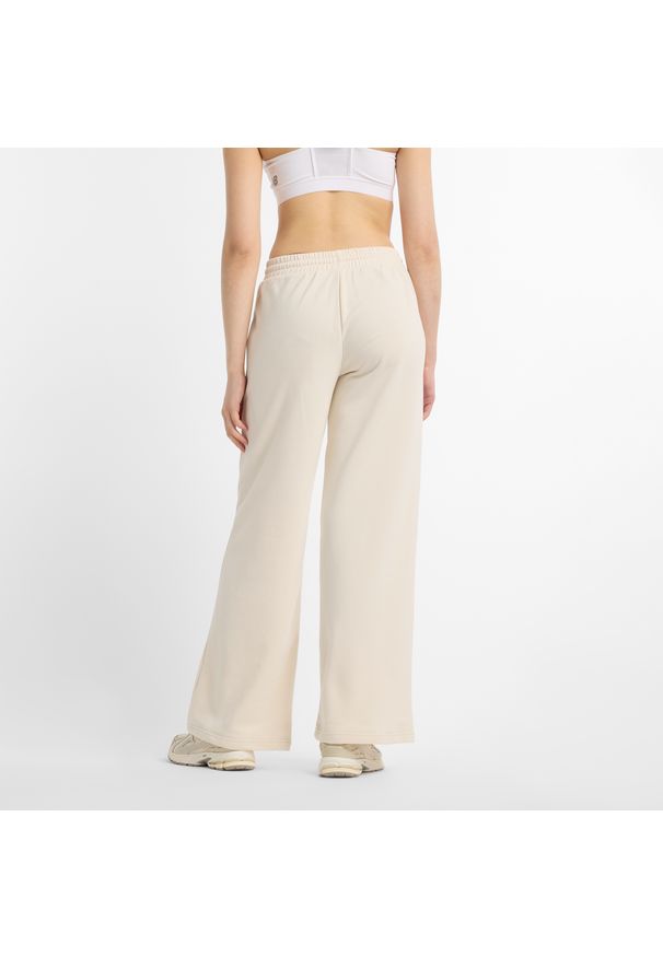 Spodnie damskie New Balance WP51503LIN – beżowe. Kolor: beżowy. Materiał: poliester, bawełna. Wzór: aplikacja, haft