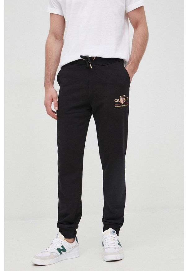 GANT - Gant spodnie dresowe 2049005. męskie kolor czarny z aplikacją. Kolor: czarny. Materiał: dresówka. Wzór: aplikacja
