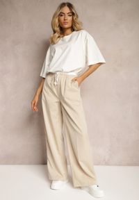 Renee - Jasnobeżowe Materiałowe Spodnie z Szerokimi Nogawkami High Waist z Gumką w Talii Comina. Okazja: na co dzień. Stan: podwyższony. Kolor: beżowy. Materiał: materiał. Styl: casual, elegancki