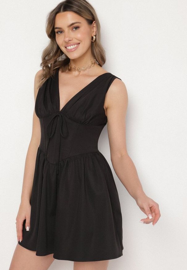 Born2be - Czarna Sukienka Vices o Rozkloszowanym Kroju z Wiązaniem Foliseia. Okazja: na co dzień. Typ kołnierza: dekolt w kształcie V. Kolor: czarny. Materiał: jeans, poliester. Długość rękawa: bez rękawów. Styl: klasyczny, casual, elegancki