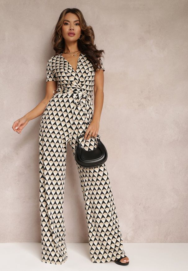 Renee - Beżowy Kopertowy Kombinezon z Krótkim Rękawem i Długimi Nogawkami Avrey. Kolor: beżowy. Materiał: tkanina, materiał. Długość rękawa: krótki rękaw. Długość: krótkie. Wzór: geometria