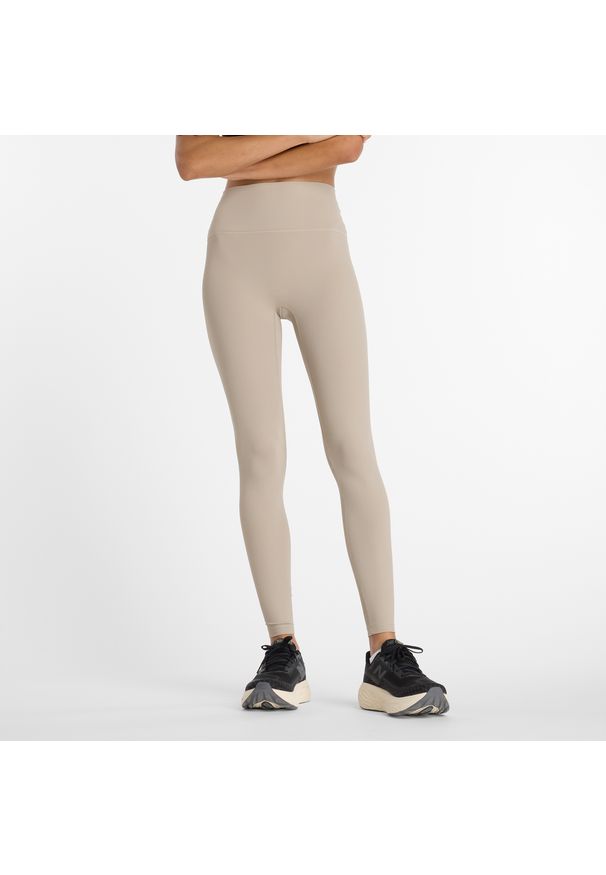 Legginsy damskie New Balance WP53152ADS – beżowe. Stan: podwyższony. Kolor: beżowy. Materiał: poliester, materiał, prążkowany. Wzór: haft. Sport: fitness