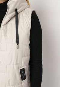 Born2be - Jasnobeżowa Pikowana Kamizelka z Kapturem i Sznurkami Imvila. Okazja: na co dzień. Typ kołnierza: kaptur. Kolor: beżowy. Materiał: jeans. Wzór: aplikacja. Styl: klasyczny, casual, elegancki #6