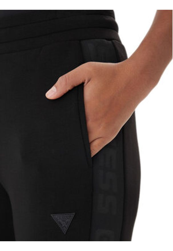 Guess Spodnie dresowe V2YB18 K7UW2 Czarny Regular Fit. Kolor: czarny. Materiał: wiskoza