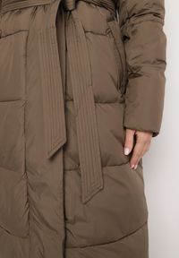 Born2be - Ciemnobeżowa Pikowana Kurtka o Długim Kroju z Kapturem i Wiązanym Paskiem Neandira. Okazja: na co dzień. Typ kołnierza: kaptur. Kolor: beżowy. Materiał: jeans, materiał. Długość rękawa: długi rękaw. Długość: długie. Sezon: zima, jesień. Styl: casual, elegancki, klasyczny #5