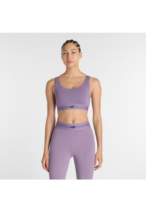 Biustonosz do treningu New Balance AC WB61Q0QKAA5 – fioletowy. Kolor: fioletowy. Materiał: tkanina, poliester, materiał. Rodzaj stanika: wyciągane miseczki, push-up. Sport: fitness
