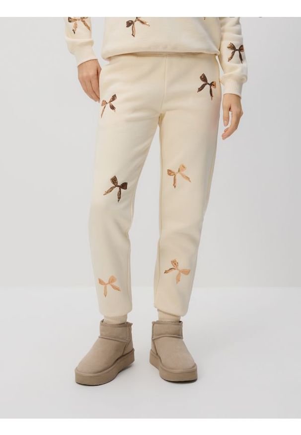 Reserved - Spodnie dresowe z aplikacjami - złamana biel. Materiał: dresówka. Wzór: aplikacja