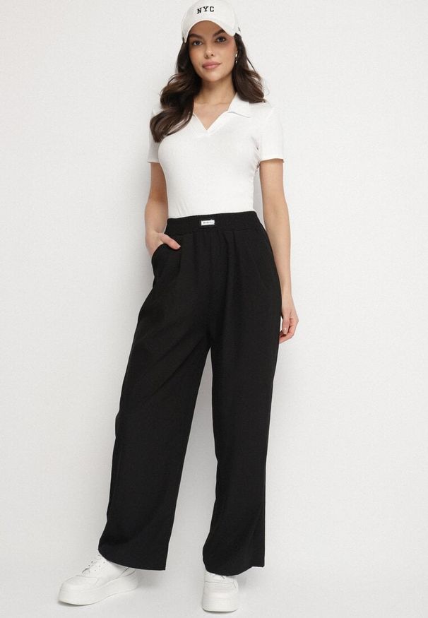 Born2be - Czarne Szerokie Spodnie z Bawełną Wysokim Stanem i Naszywką Nannirea. Okazja: na co dzień. Stan: podwyższony. Kolor: czarny. Materiał: bawełna. Wzór: aplikacja. Styl: elegancki, casual, klasyczny