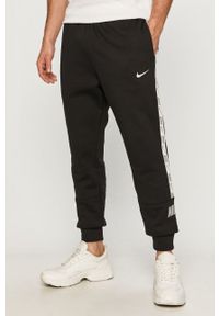 Nike Sportswear - Spodnie. Kolor: czarny. Materiał: bawełna, poliester, dzianina. Wzór: aplikacja #1