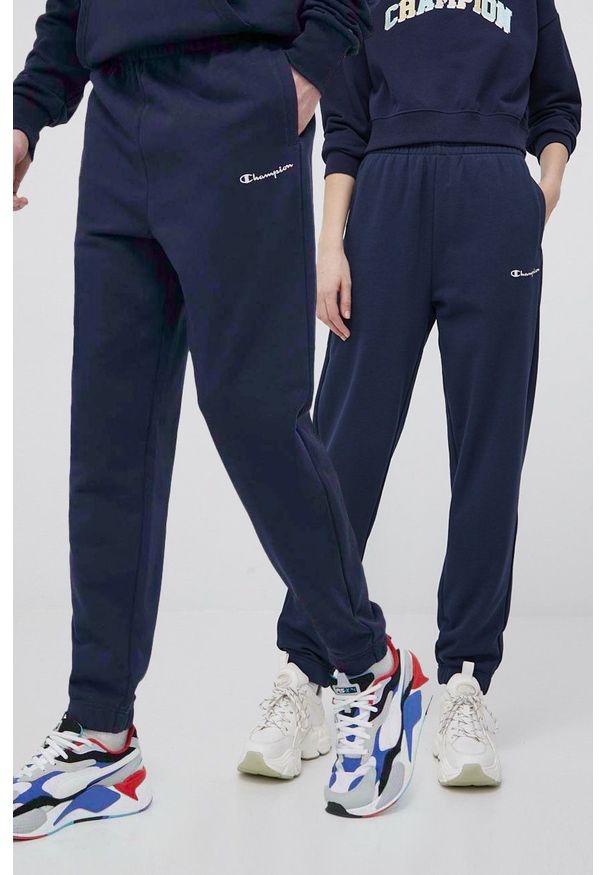 Champion spodnie 217404 kolor granatowy z aplikacją. Kolor: niebieski. Materiał: włókno, dzianina, materiał. Wzór: aplikacja