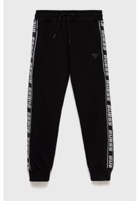Guess spodnie dresowe dziecięce kolor czarny z aplikacją. Okazja: na co dzień. Kolor: czarny. Materiał: dresówka. Wzór: aplikacja. Styl: casual #1