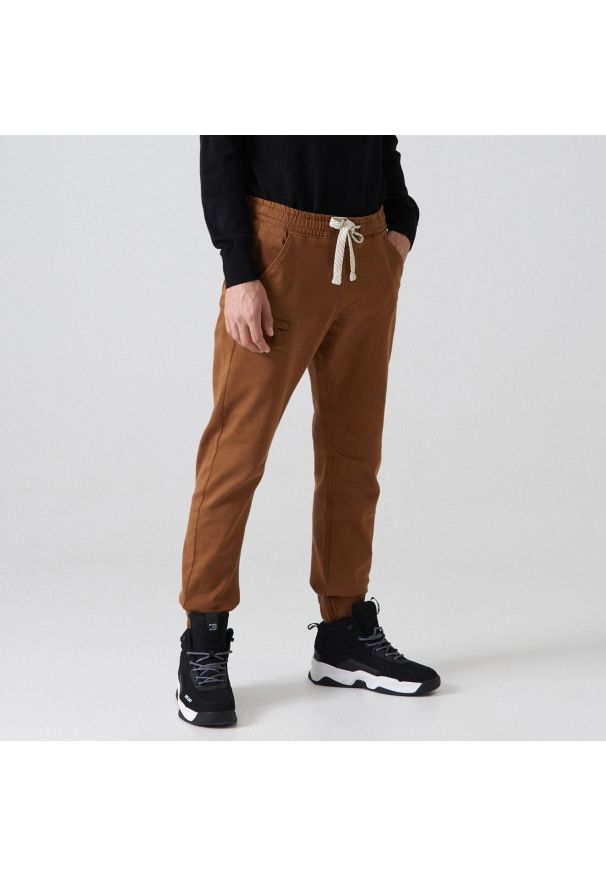 Cropp - Spodnie typu jogger - Brązowy. Kolor: brązowy. Materiał: bawełna, tkanina