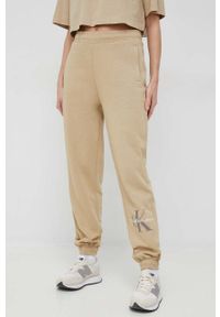 Calvin Klein Jeans spodnie dresowe damskie kolor beżowy z nadrukiem. Kolor: beżowy. Materiał: dresówka. Wzór: nadruk #4