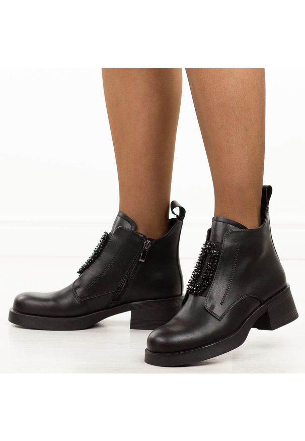 Czarne skórzane botki damskie DiA 52-869. Okazja: do pracy, na co dzień. Nosek buta: okrągły. Kolor: czarny. Szerokość cholewki: normalna. Wzór: aplikacja. Materiał: skóra. Sezon: zima, jesień. Obcas: na obcasie. Styl: klasyczny, casual, elegancki. Wysokość obcasa: niski