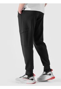 4f - Spodnie dresowe joggery męskie - czarne. Kolor: czarny. Materiał: dresówka. Wzór: ze splotem, gładki. Sport: fitness