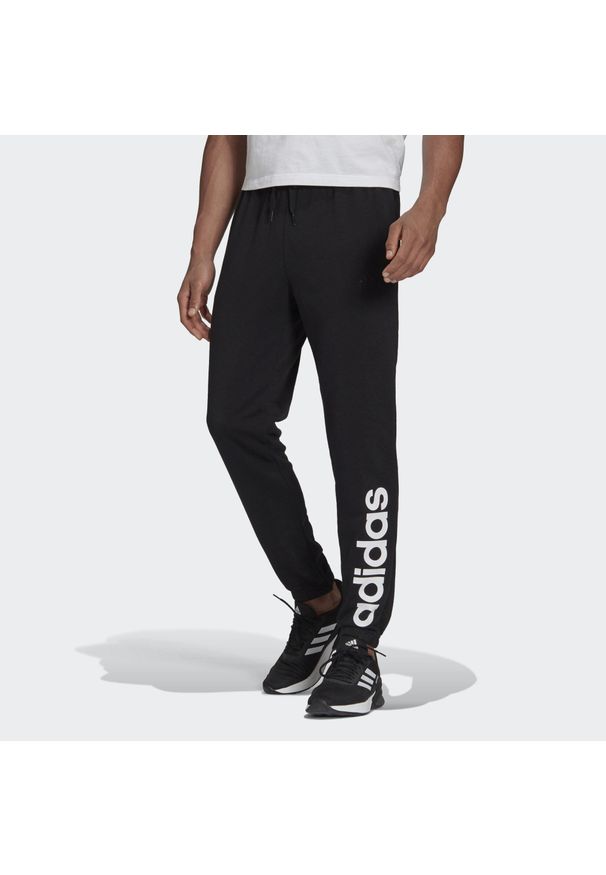 Adidas - Spodnie adidas Essentials Tapered Elastic Cuff Linear. Kolor: czarny. Materiał: bawełna. Sport: fitness