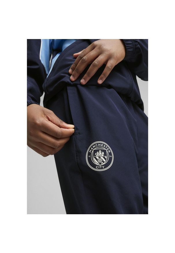 Puma - Młodzieżowe spodnie Manchester City ftblARCHIVE PUMA Navy Team Light Blue. Kolor: niebieski