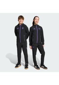 Adidas - Spodnie Manchester United Tiro 25 Competition Vis Tech Travel Kids. Kolor: fioletowy, wielokolorowy, czarny. Sport: piłka nożna