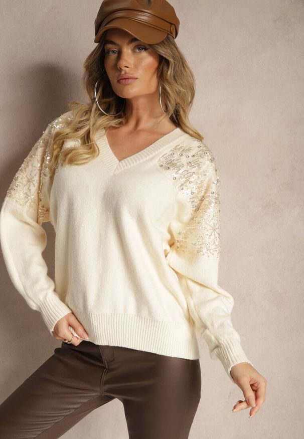 Renee - Jasnobeżowy Sweter o Kroju Nietoperza Ozdobiony Cekinami i Cyrkoniami Nevarraea. Okazja: na co dzień. Kolor: beżowy. Materiał: jeans. Wzór: aplikacja. Styl: klasyczny, casual, elegancki