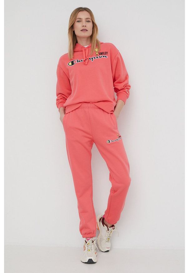 Champion spodnie dresowe CHAMPION X SMILEY 115934 damskie kolor różowy z aplikacją. Stan: podwyższony. Kolor: różowy. Materiał: dresówka. Wzór: aplikacja