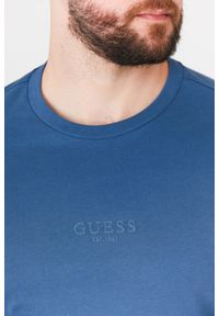 Guess - GUESS Niebieski t-shirt męski z aplikacją z logo. Kolor: niebieski. Wzór: aplikacja