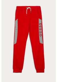 Guess Jeans - Spodnie dziecięce 116-175. Kolor: czerwony. Materiał: bawełna, jeans, dzianina. Wzór: aplikacja #1