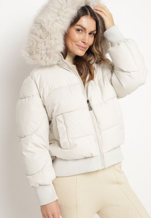 Born2be - Jasnobeżowa Pikowana Kurtka z Szerokimi Ściągaczami i Ozdobnym Futrem przy Kapturze Inandria. Okazja: do pracy, na co dzień, na spotkanie biznesowe. Kolor: beżowy. Materiał: futro. Długość rękawa: długi rękaw. Długość: długie. Styl: klasyczny, casual, elegancki, biznesowy