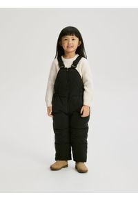 Reserved - Gumowane spodnie na szelkach - czarny. Kolor: czarny. Materiał: materiał #1