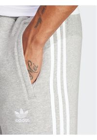 Adidas - adidas Spodnie dresowe adicolor 3-Stripes IM9318 Szary Slim Fit. Kolor: szary. Materiał: syntetyk