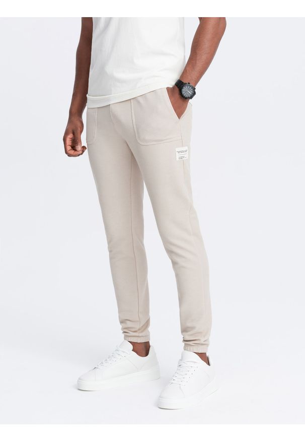 Ombre Clothing - Męskie spodnie dresowe ze strukturalnej dzianiny - jasnobeżowe V1 - Rozmiar: L. Kolor: beżowy. Materiał: dresówka, dzianina. Wzór: melanż, aplikacja, ze splotem. Styl: elegancki