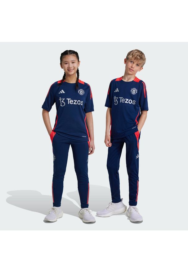 Adidas - Spodnie Manchester United Tiro 24 Training Kids. Kolor: czerwony, niebieski, wielokolorowy. Materiał: materiał, dresówka. Sport: piłka nożna