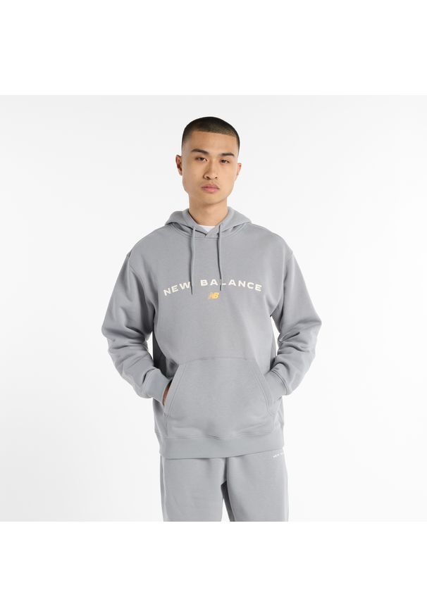 Bluza męska New Balance MT51516YST – szara. Typ kołnierza: kaptur. Kolor: szary. Materiał: bawełna, poliester, dresówka, materiał. Wzór: aplikacja, napisy