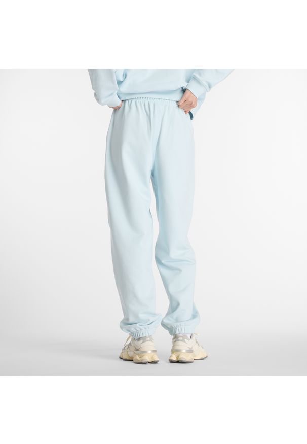Spodnie damskie New Balance WP41513FRL – niebieskie. Stan: podwyższony. Kolor: niebieski. Materiał: dresówka, bawełna. Wzór: ze splotem