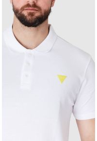 Guess - GUESS Biała koszulka polo z żółtym logo. Typ kołnierza: polo. Kolor: biały. Materiał: prążkowany. Długość rękawa: krótki rękaw. Wzór: aplikacja #3