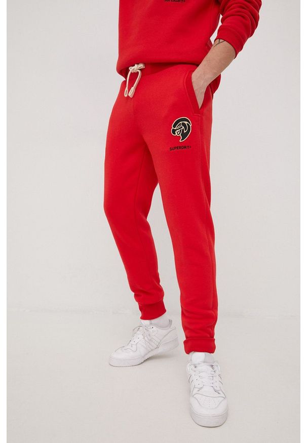 Superdry spodnie dresowe męskie kolor czerwony z aplikacją. Kolor: czerwony. Materiał: dresówka. Wzór: aplikacja
