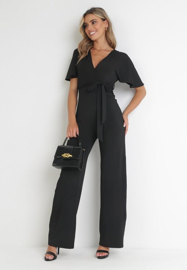 Born2be - Czarny Długi Kombinezon z Kopertowym Dekoltem i Ozdobnym Wiązaniem Abrarani. Okazja: na spotkanie biznesowe. Kolor: czarny. Długość: długie. Styl: elegancki, biznesowy