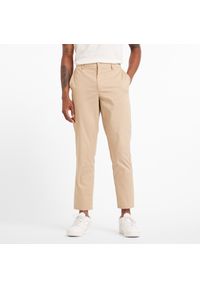 Spodnie męskie New Balance MP43554SOT – beżowe. Kolor: beżowy. Materiał: nylon, materiał, bawełna. Wzór: aplikacja