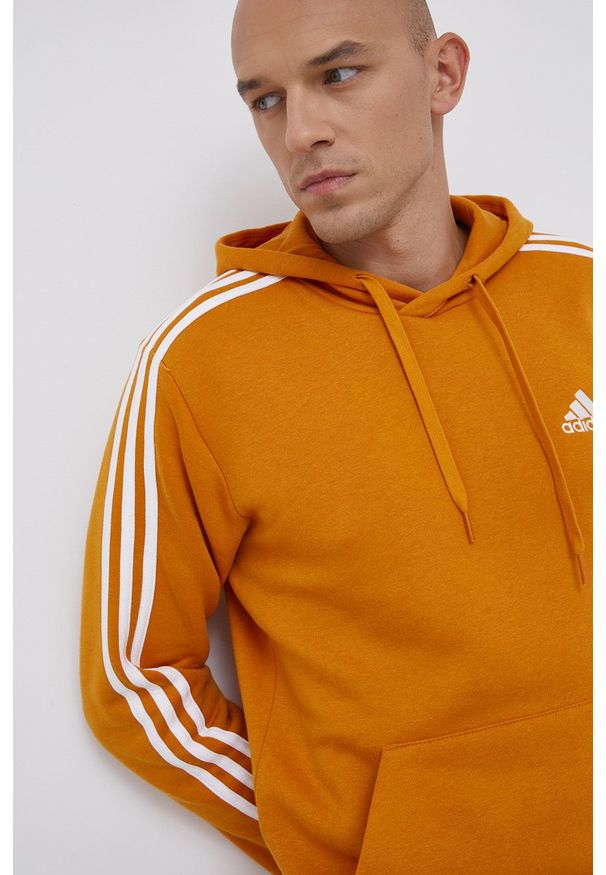 Adidas - adidas Bluza męska kolor pomarańczowy z kapturem gładka. Okazja: na co dzień. Typ kołnierza: kaptur. Kolor: pomarańczowy. Materiał: bawełna, materiał, dzianina. Wzór: aplikacja, gładki. Styl: casual