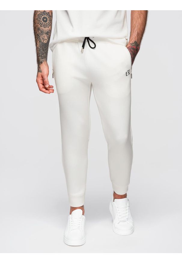 Ombre Clothing - Dresowe spodnie męskie ze ściągaczami w nogawkach i gumowym nadrukiem – białe V2 - Rozmiar: M. Kolor: biały. Materiał: guma, dresówka. Wzór: nadruk. Styl: elegancki, sportowy