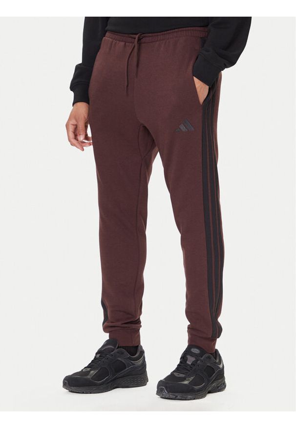 Adidas - adidas Spodnie dresowe Essentials 3-Stripes JX0749 Brązowy Regular Fit. Kolor: brązowy. Materiał: bawełna, syntetyk
