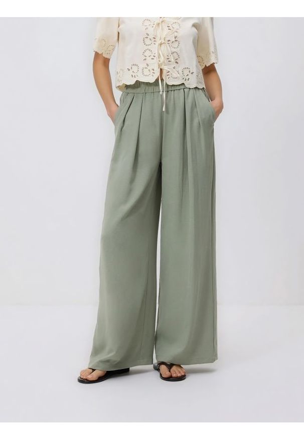 Reserved - Szerokie spodnie - ciemnozielony. Kolor: zielony. Materiał: tkanina. Wzór: gładki
