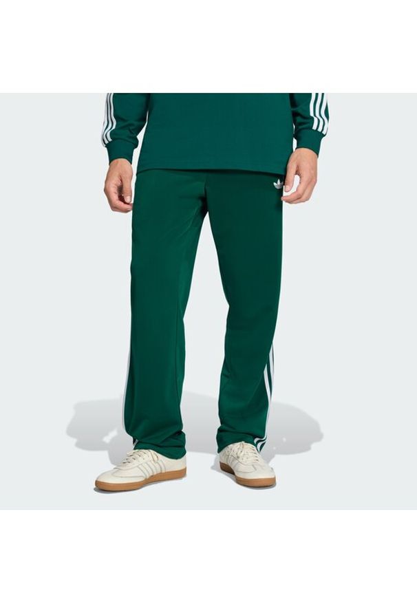 Adidas - adidas Spodnie dresowe Firebird KD8317 Zielony Loose Fit. Kolor: zielony. Materiał: syntetyk